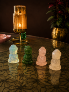 1 inch full body Buddha crystal figurines in different healing stones displayed on a decorative table